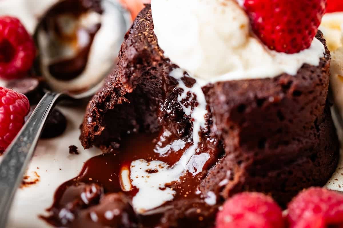 Chocolate lava cake with vanilla ice cream and fresh raspberries on a candlelit table